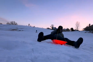 Jordie Lane sledding through snow