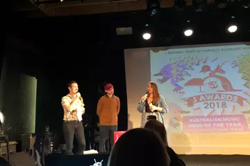 Claudia Sangiorgi Dalimore accepting the award from triple's Ben & Liam