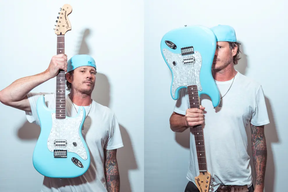 Tom DeLonge holding his signature Fender guitar