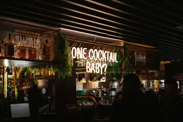 Bar with 'One Cocktail Baby?' sign