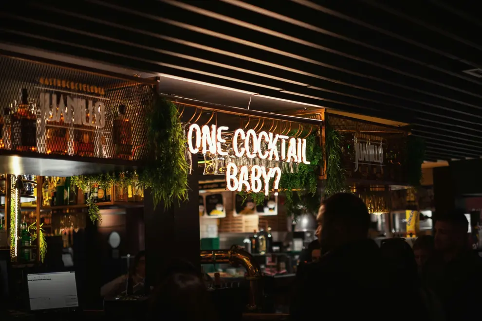 Bar with 'One Cocktail Baby?' sign